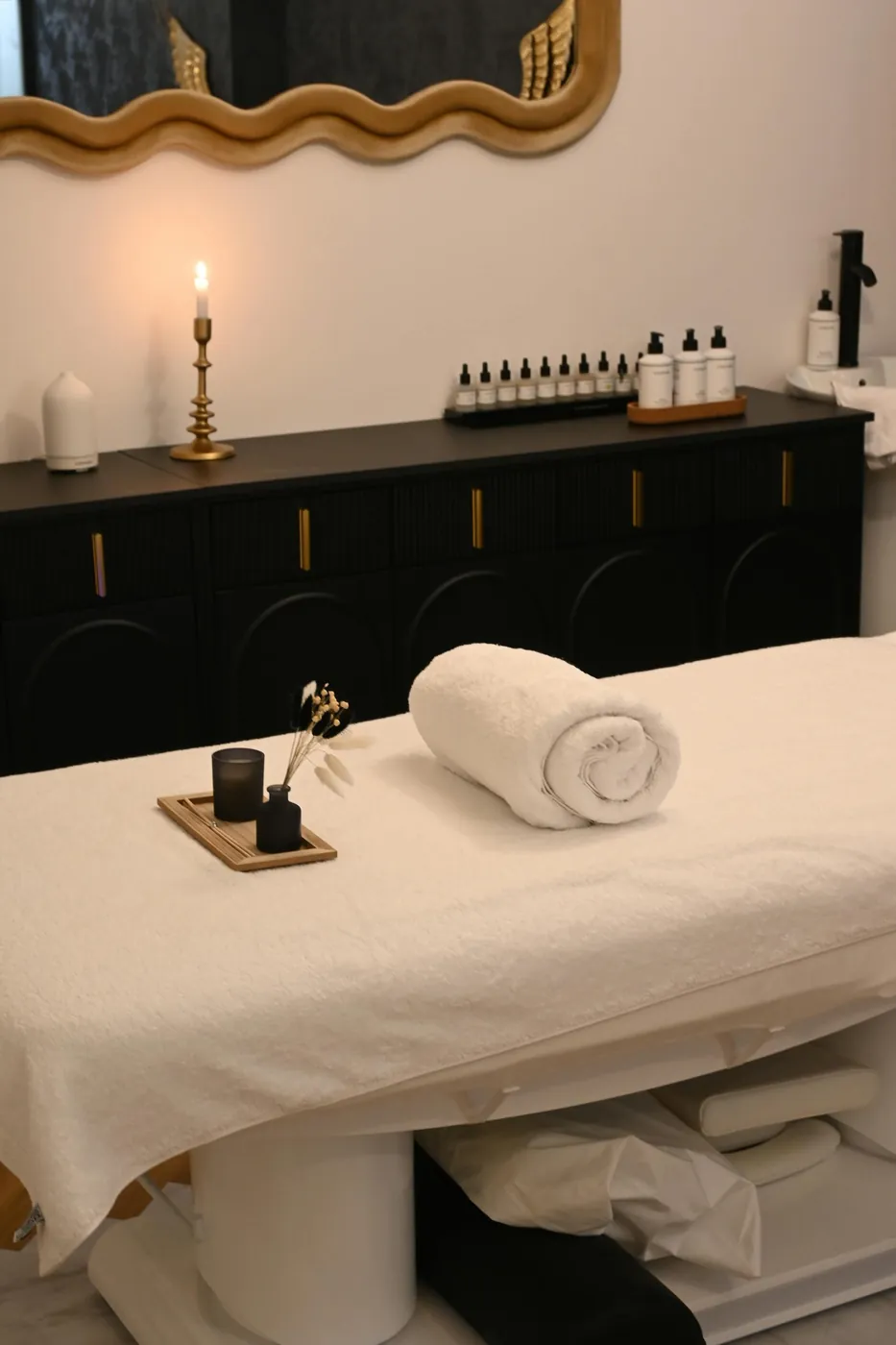 A quiet massage room with a treatment table and warm candlelight