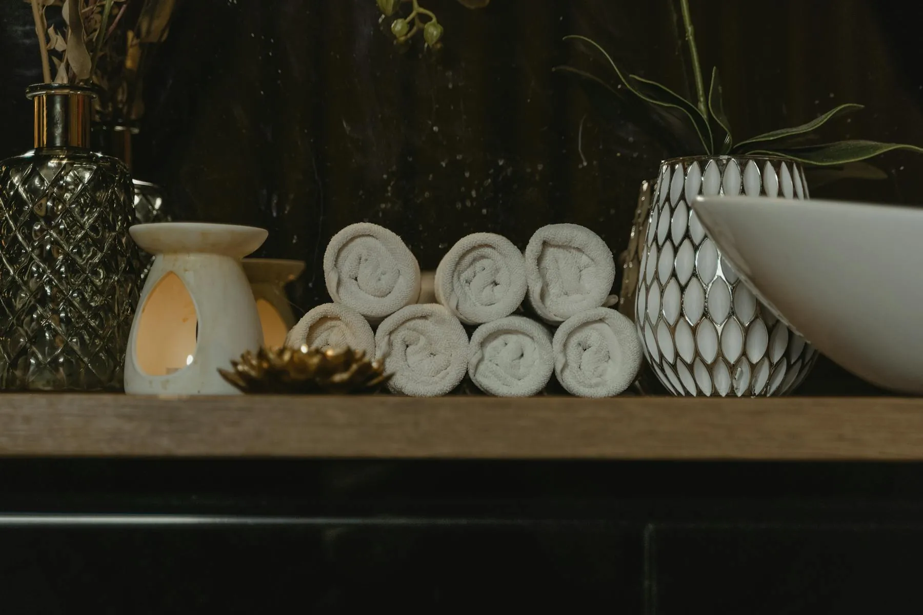 Rolled towels and candles in a calm spa setting
